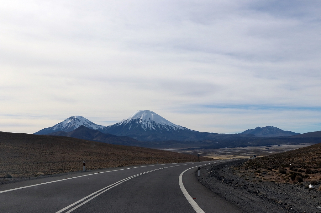 Fahrt auf der Ruta 11 - Im Hintergrund die Zwillingsvulkane Pomerape (6.250 m.ü.M) und Parinacota (6.348 m.ü.M)